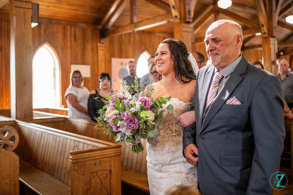 Wedding ceremony in a rustic church with wooden beams and natural lighting.