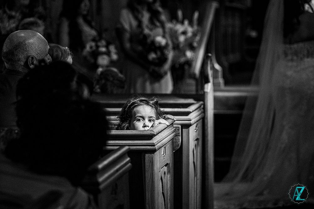 Artistic black and white photograph capturing a quiet moment during a church wedding ceremony.