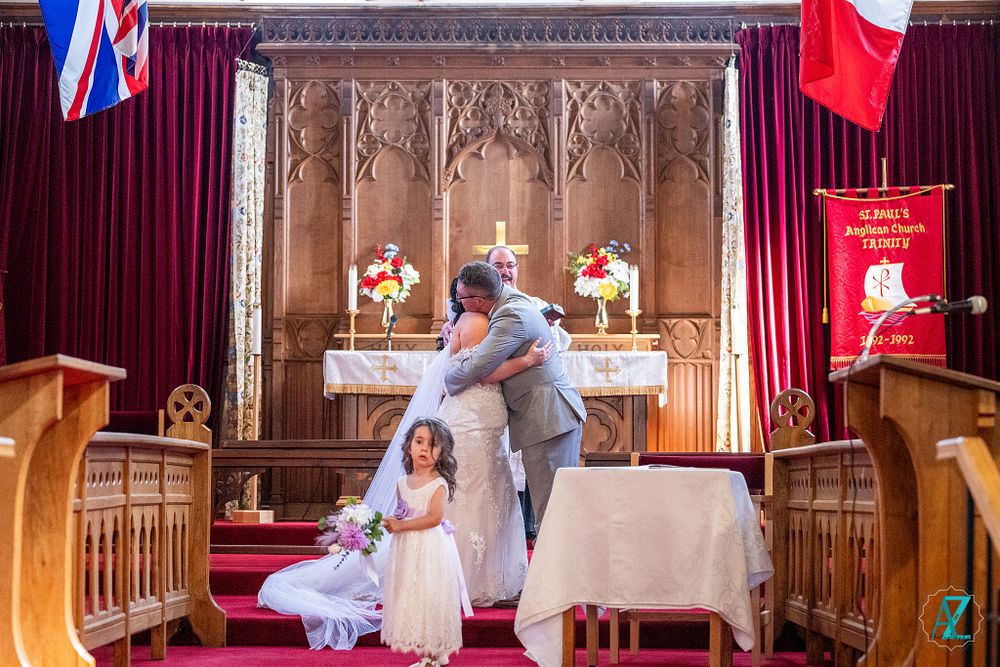 A romantic moment unfolds at the altar of a church with ornate carved wall details.