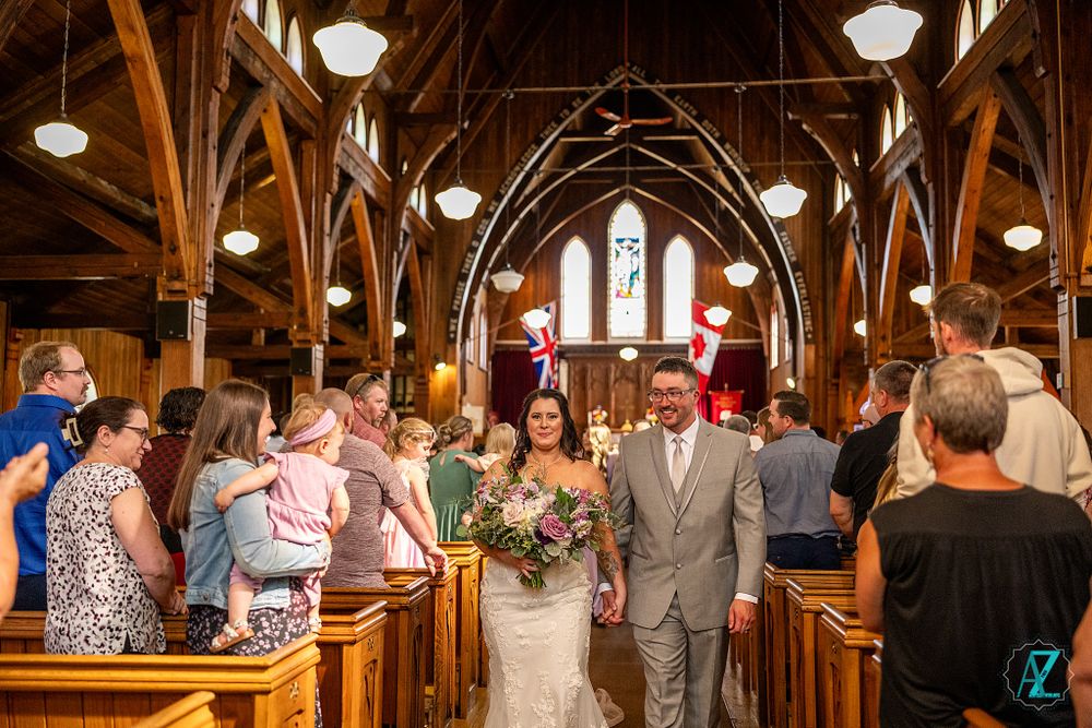 Wedding ceremony in a beautiful gothic church with wooden arches and stained glass windows.