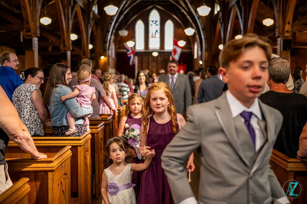 Wedding celebration in progress inside ornate church with gothic architecture and wooden pews.