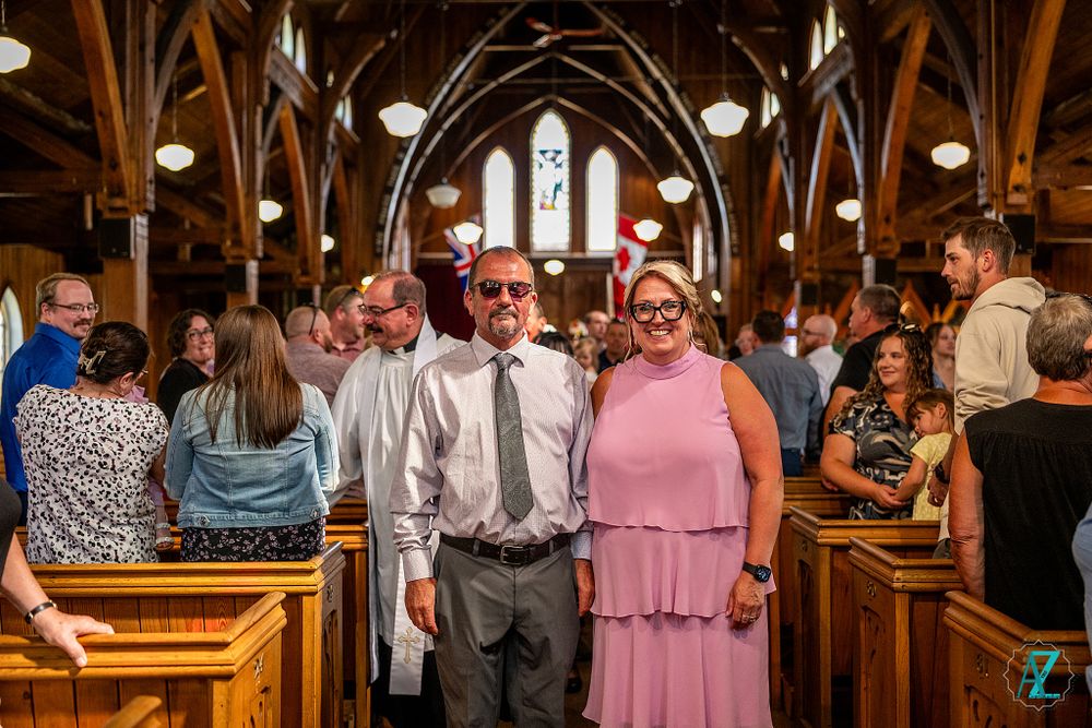Guests standing in church pews during a special celebration with gothic architecture visible in background.