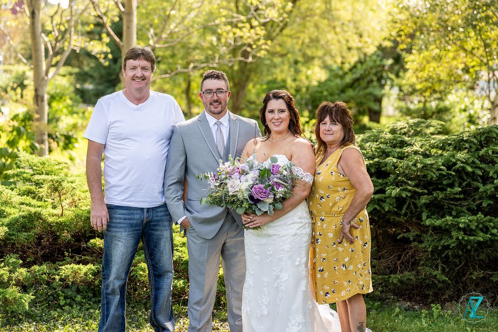 Wedding portrait in garden setting with casual and formal attire mix.