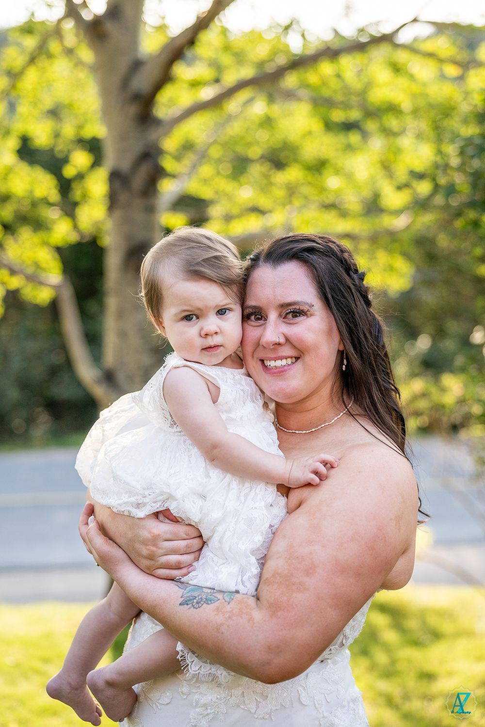 A heartwarming moment captured outdoors during a summer wedding celebration.