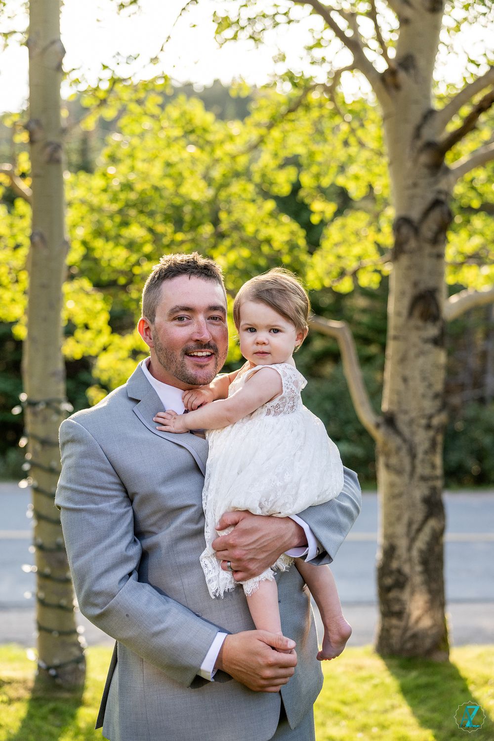 A touching moment captured during an outdoor wedding celebration with birch trees in the background.