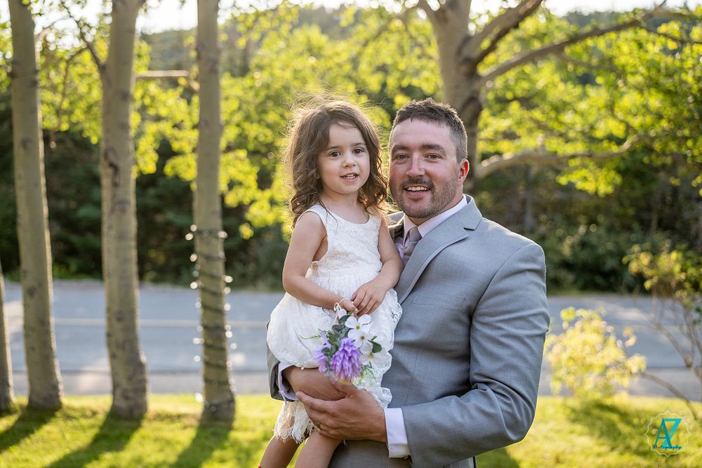 A sweet outdoor wedding moment captured in golden evening light under birch trees.