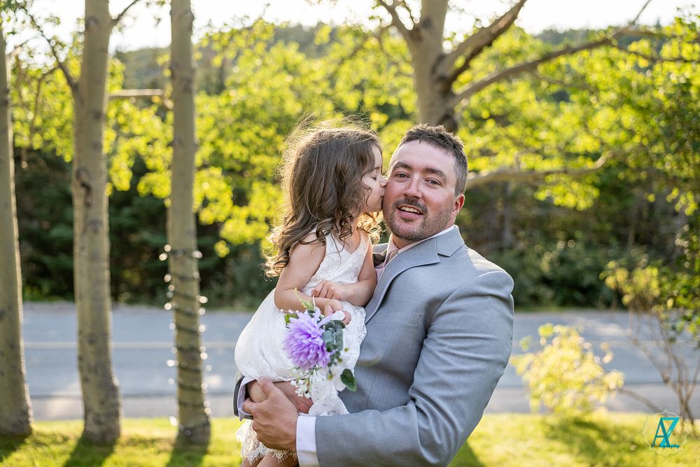 A playful wedding moment photographed in a natural setting with birch trees.