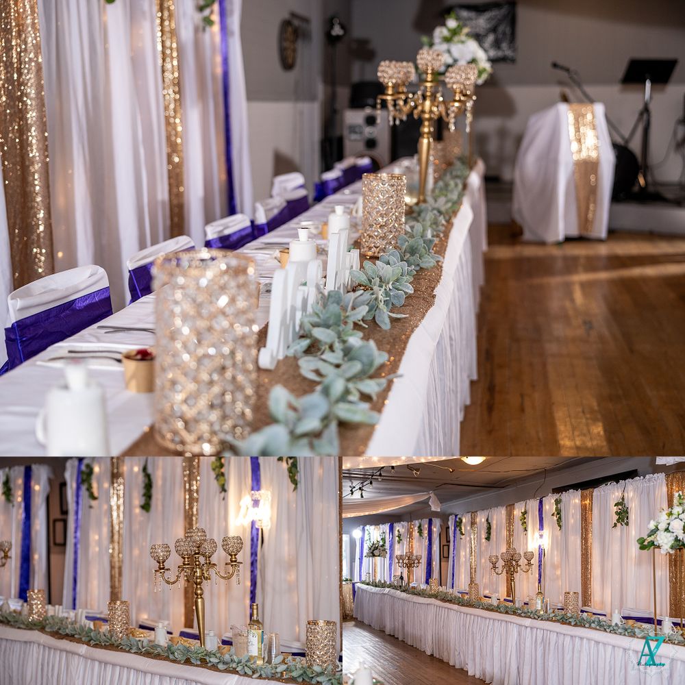 Elegant wedding reception decor featuring gold candelabras and purple accents on long white-draped tables.