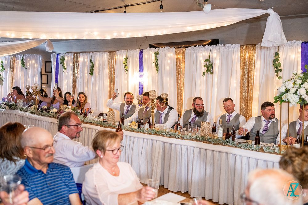Wide view of wedding reception showing decorated tables and guests enjoying the celebration.