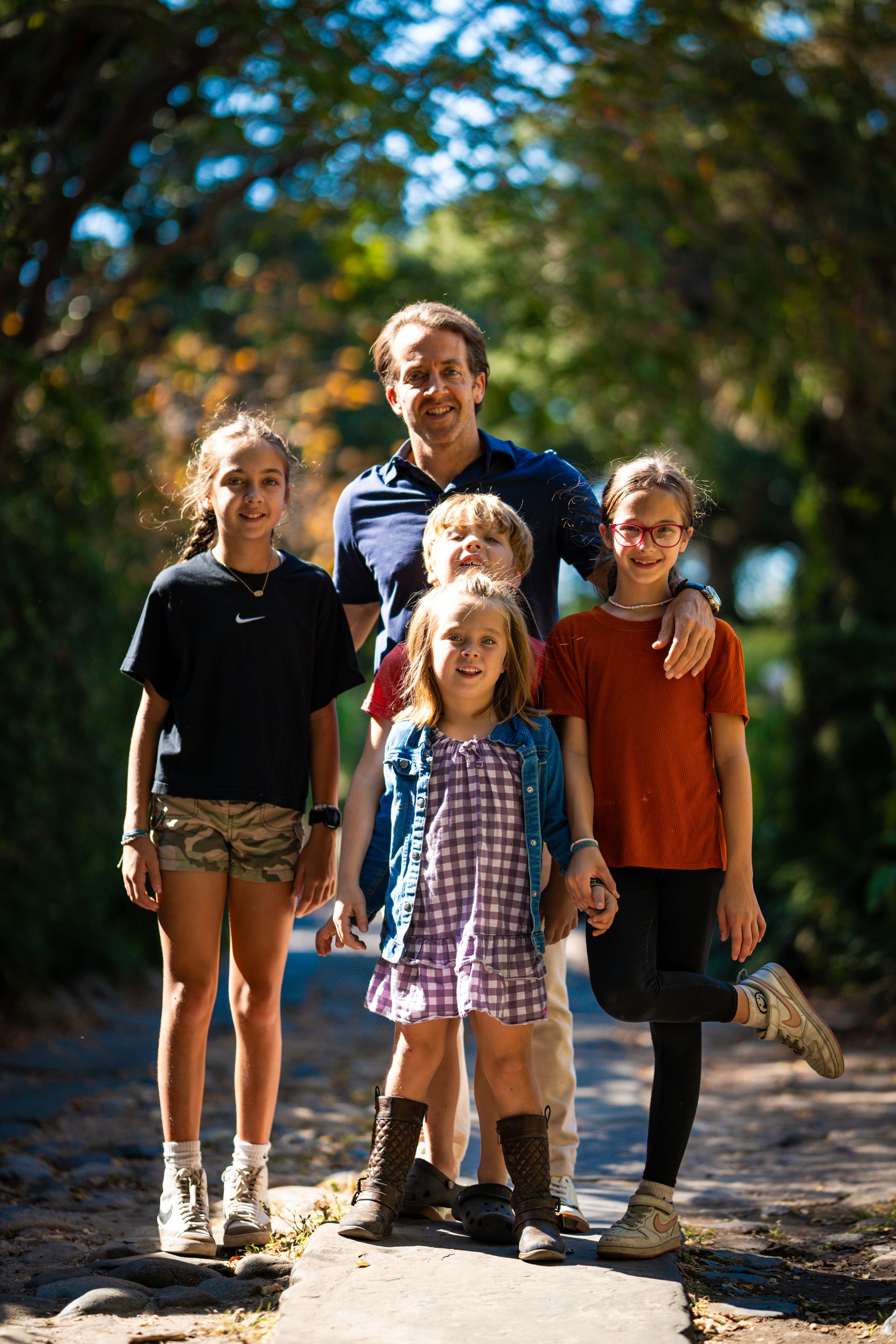 Group hiking together on sunny outdoor trail through wooded area.