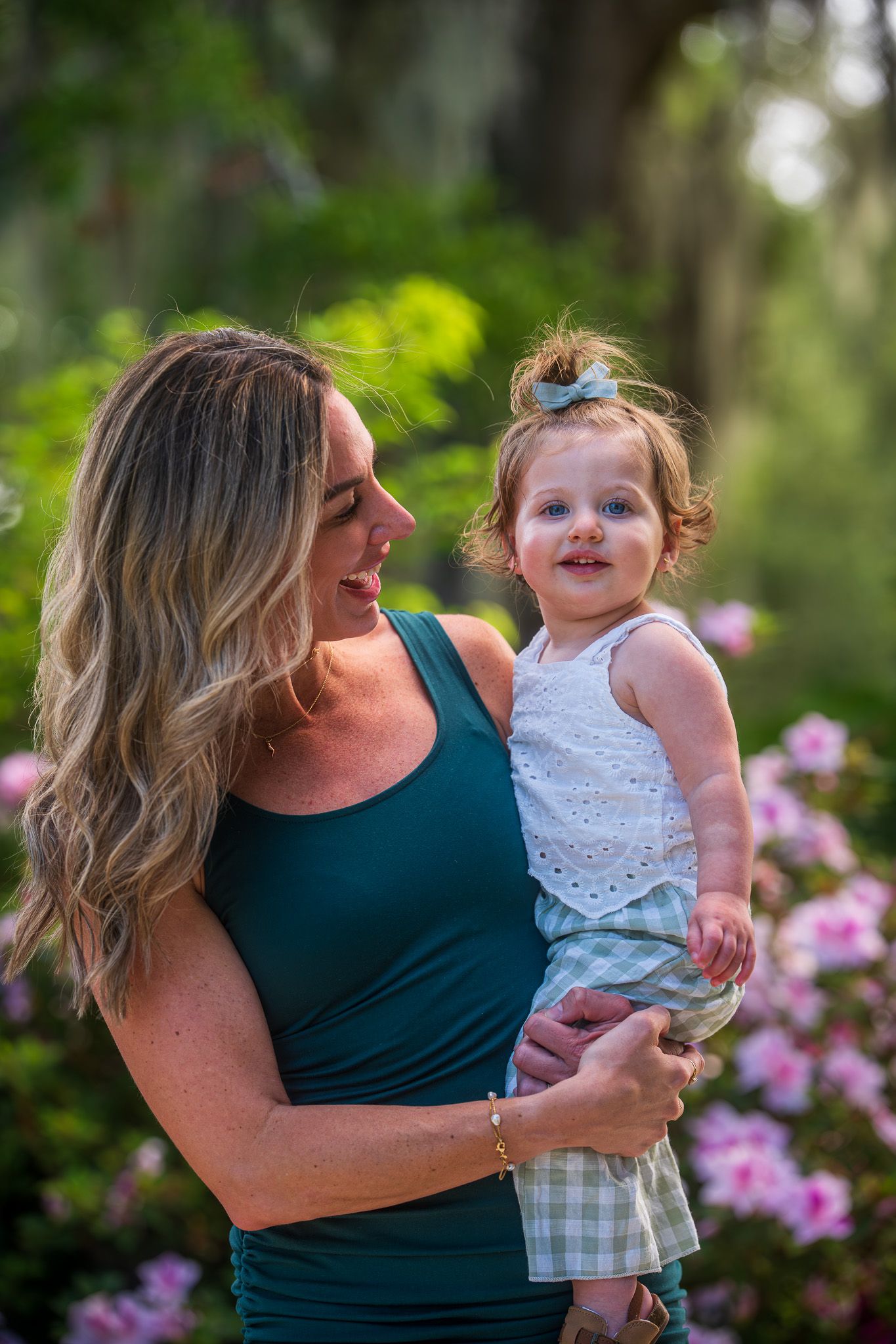 Family sharing tender moments together in a garden with blooming flowers.