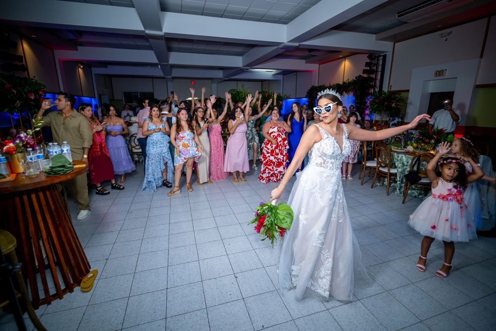 A joyous wedding reception scene with guests celebrating in a decorated indoor venue.