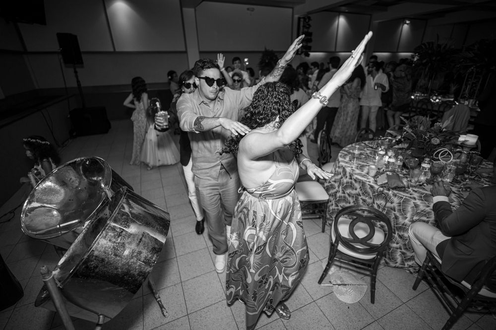 A black and white candid shot of energetic wedding reception dancing.
