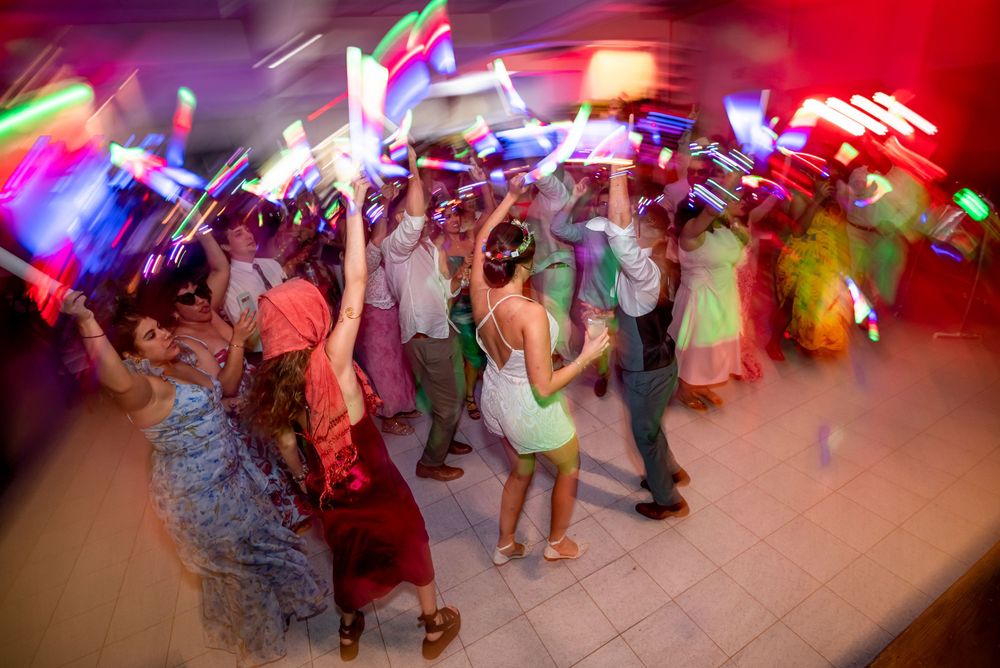 A colorful motion-blurred shot of wedding reception dancing with vibrant light trails.