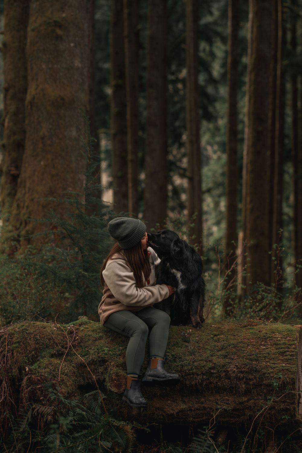 Owner and dog on a log in Seattle Washington.