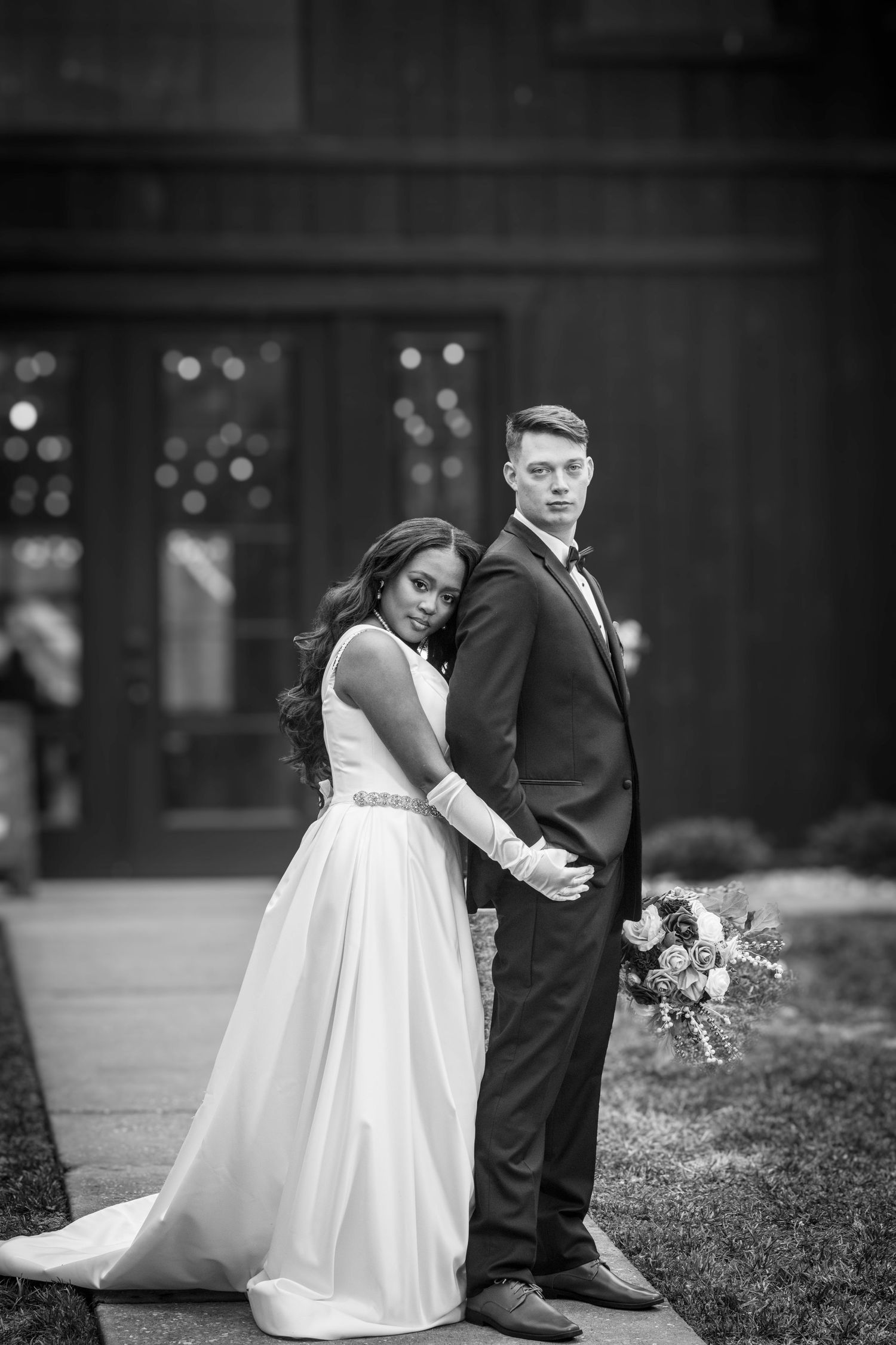 Black and white portrait of a couple in wedding attire.