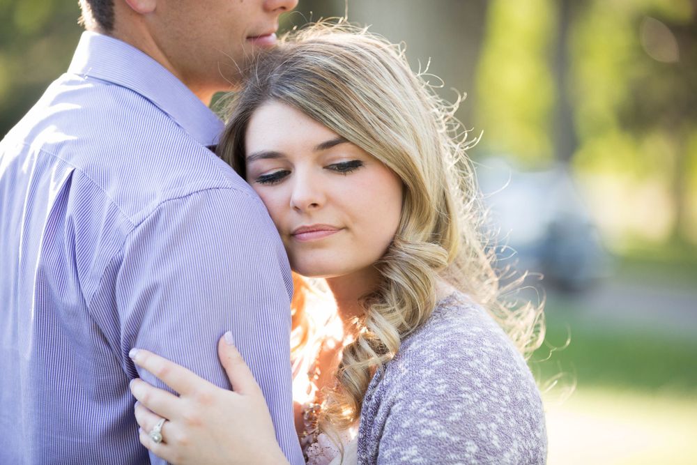 Intimate portrait of a couple in coordinated outfits against a blurred nature backdrop.