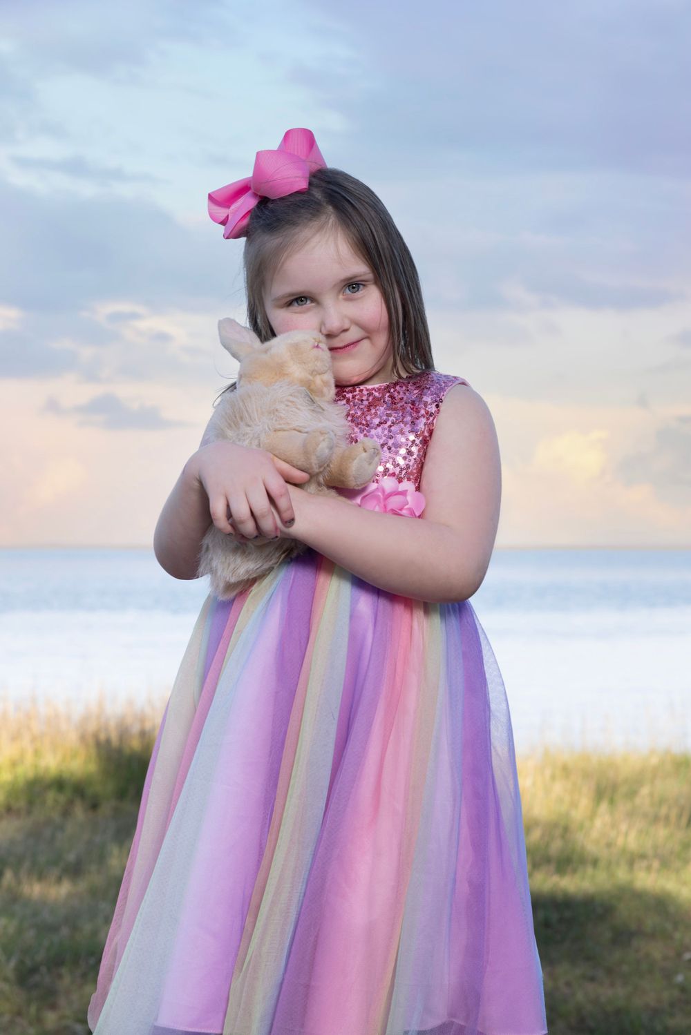 photo of young girl holding a stuffed animal