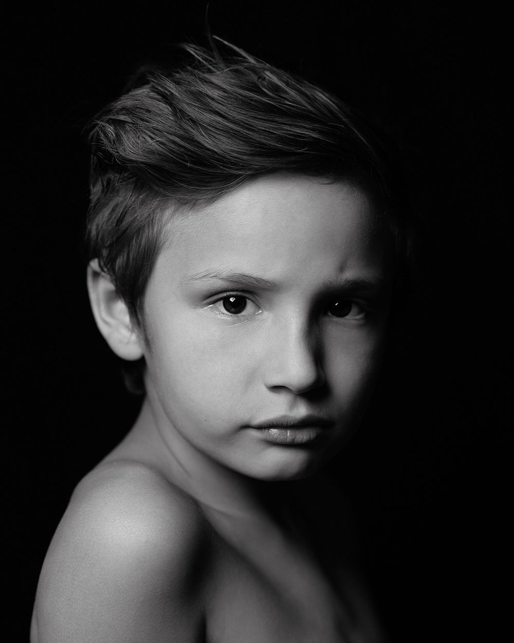 black and white image of young boy dramatic lighting