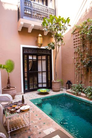 Moroccan riad courtyard with small plunge pool, terracotta tiles, and traditional decor.