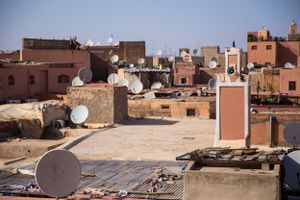 Rooftop view of traditional Moroccan buildings with satellite dishes in Marrakech.
