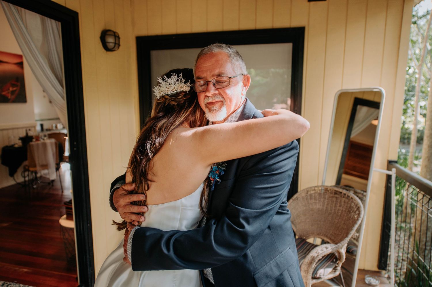 An emotional embrace shared during wedding day preparations indoors.