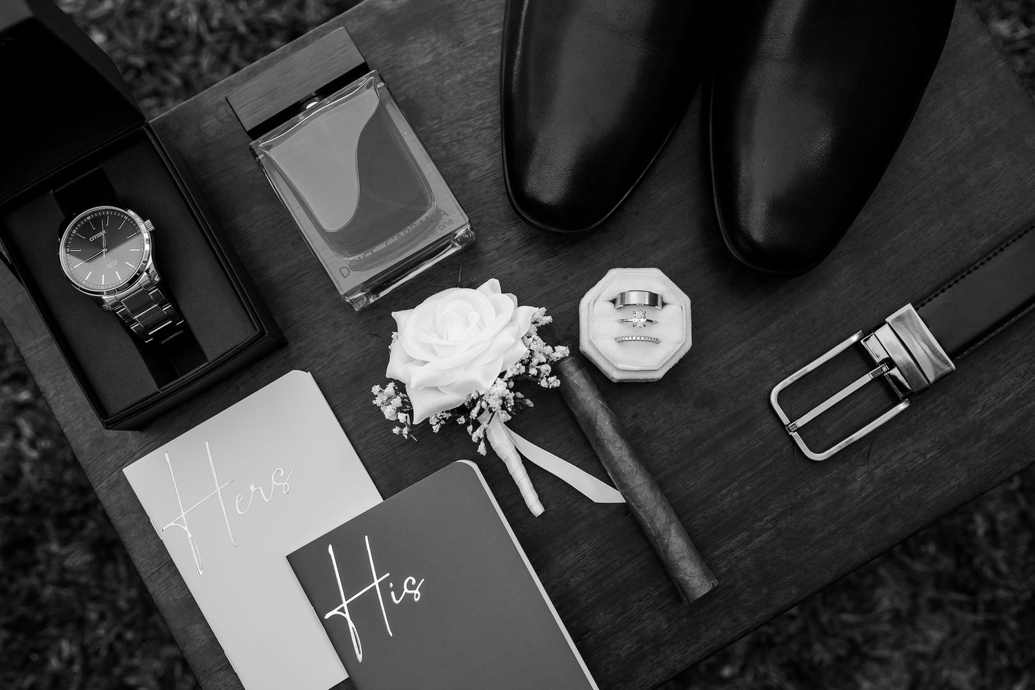 A romantic black and white photo of a couple sharing an intimate moment behind a wide-brimmed hat at raglan wedding venue.