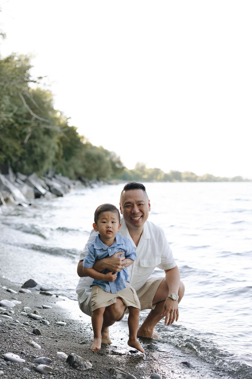 A heartwarming beach scene shows quality family time together on the rocky shoreline.