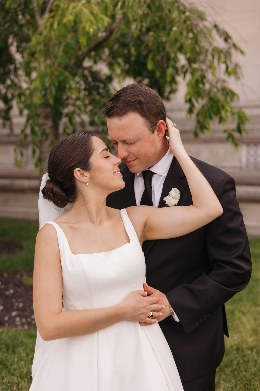 Romantic couple in wedding attire sharing intimate moments in a garden setting.
