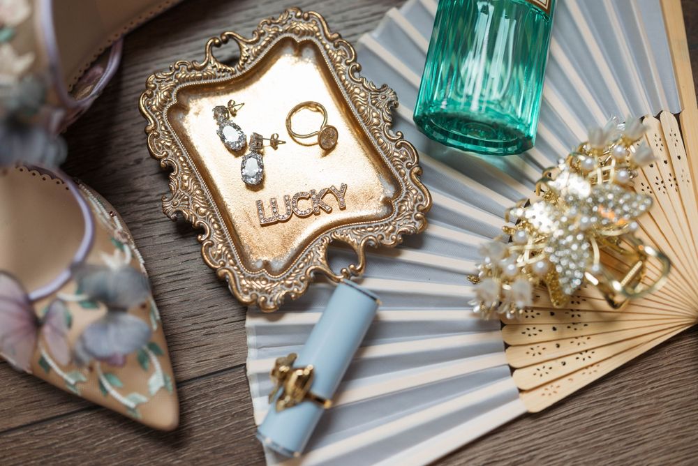 Wedding accessories including vintage frames and turquoise vases arranged on wooden surface.