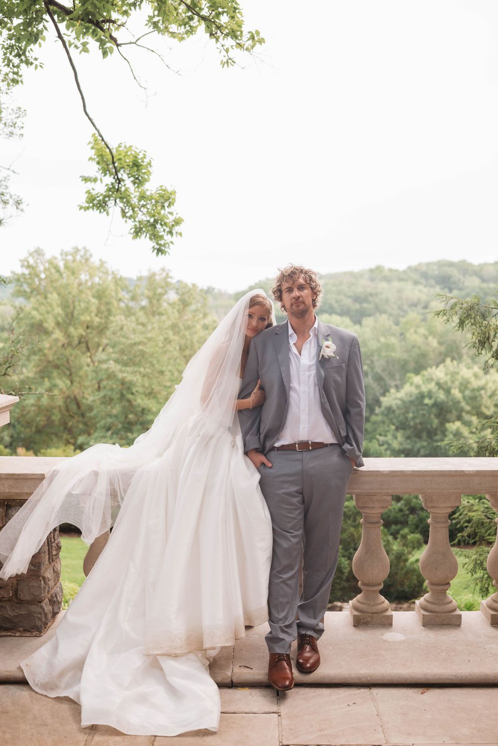 Couple shares tender moment on stone terrace overlooking scenic landscape.