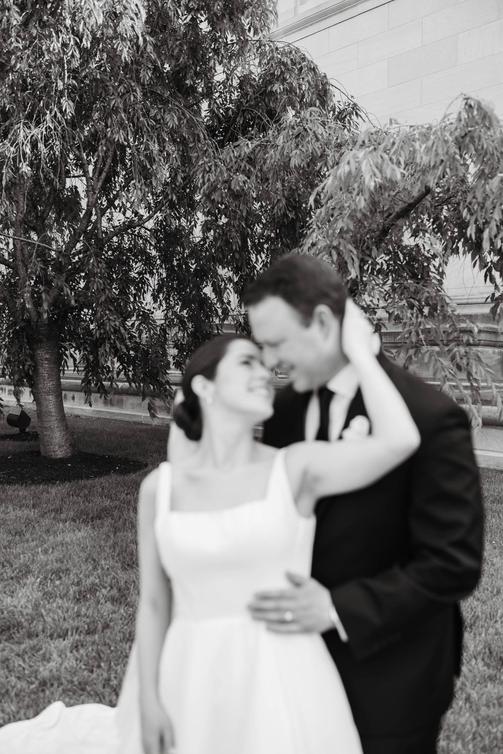 Black and white photo series showing a romantic couple embracing outdoors under trees.