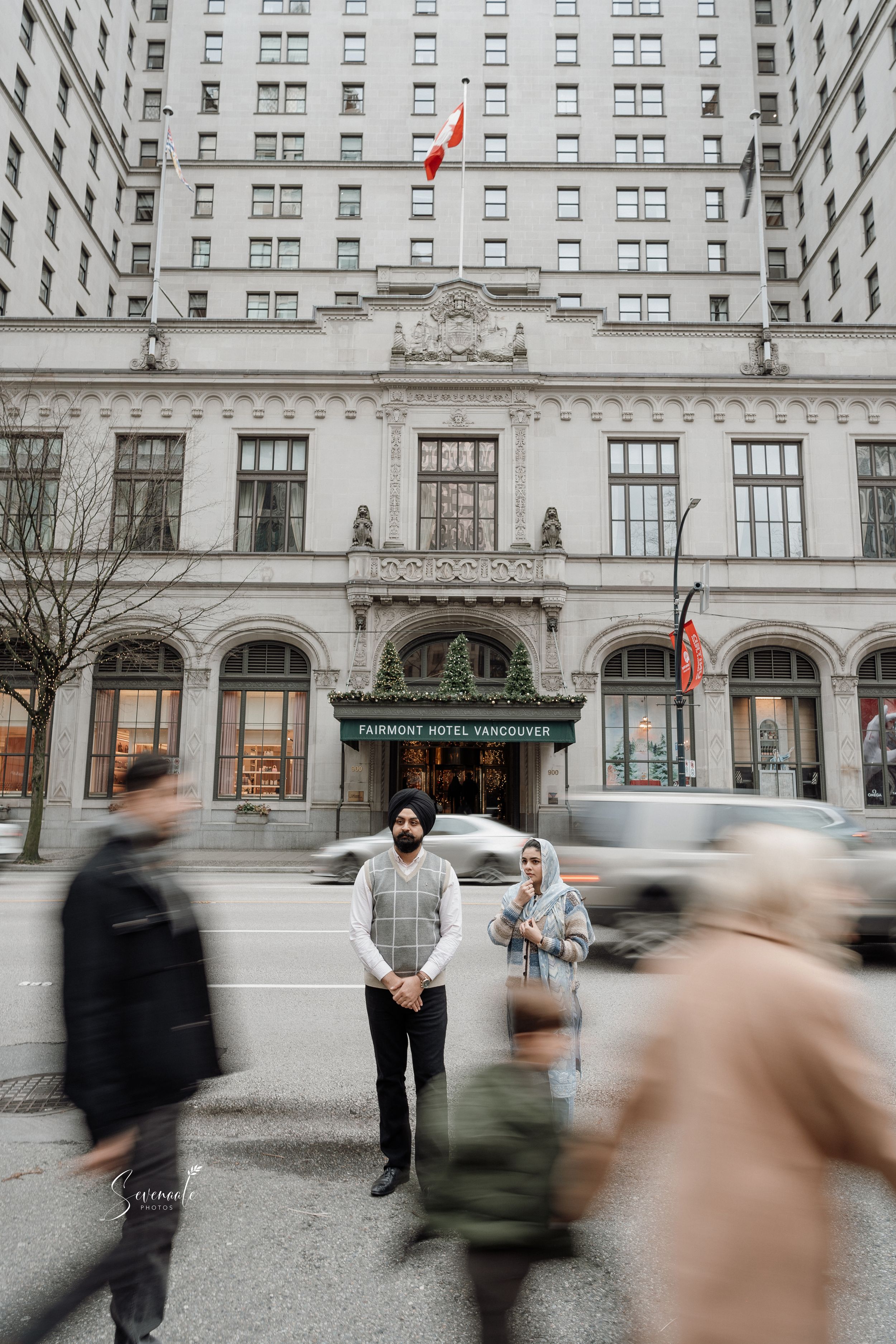 Elegant hotel entrance with blurred pedestrians passing by on a cloudy city day.