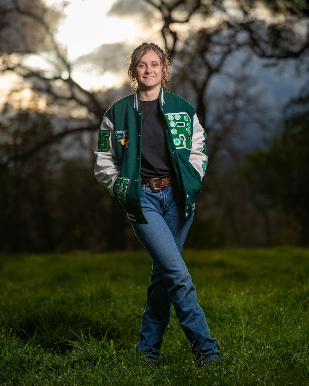 Athletic letterman jacket portrait against sunset with moody lighting.