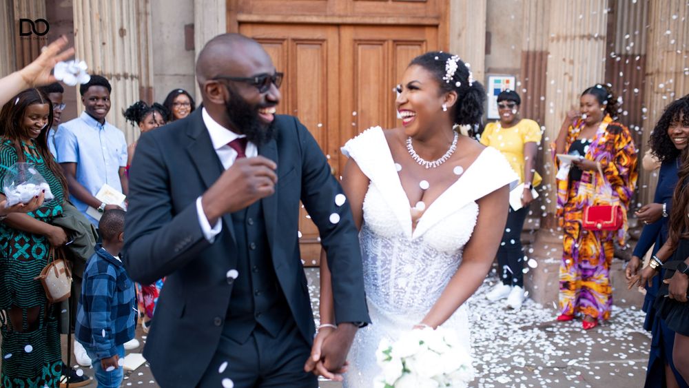 Joyful wedding celebration with guests dancing and confetti flying in the air at an elegant indoor venue.