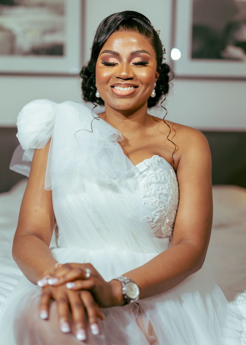 A bride in a white wedding gown with delicate lace details and flutter sleeves poses elegantly during a photo session.