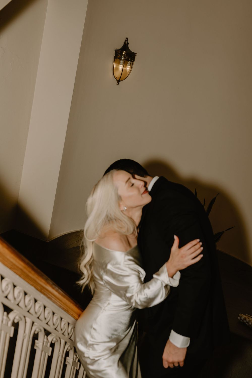 Courthouse elopement photo. Bride silk white dress. Courthouse steps. Bucks County Wedding Photographer, Couple kissing on staircase. Moody
