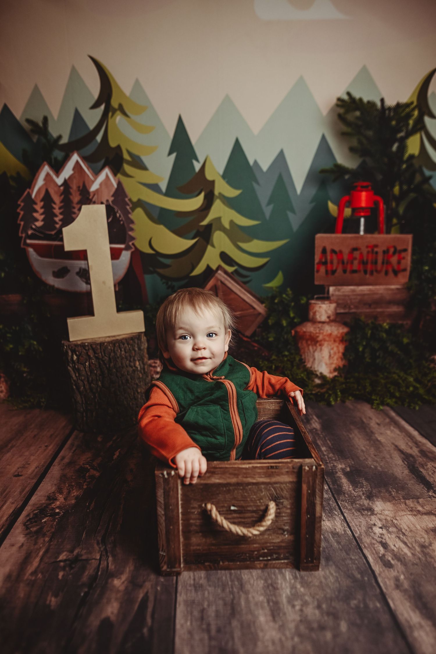 Woodland themed first birthday setup with rustic decor and adventure backdrop.