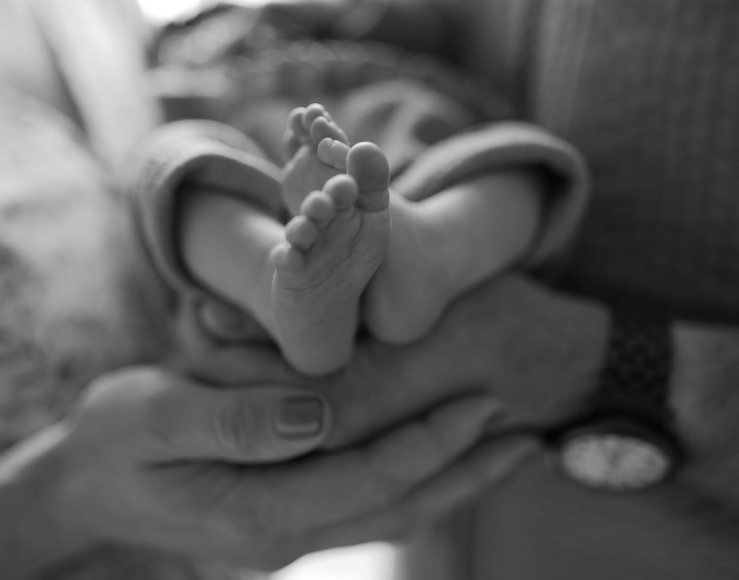 Intimate black and white portrait of new parents with their newborn baby.