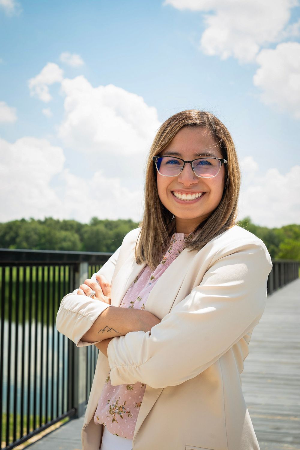 A series of outdoor portraits showing someone in a cream blazer and glasses posing against a sunny waterfront backdrop.