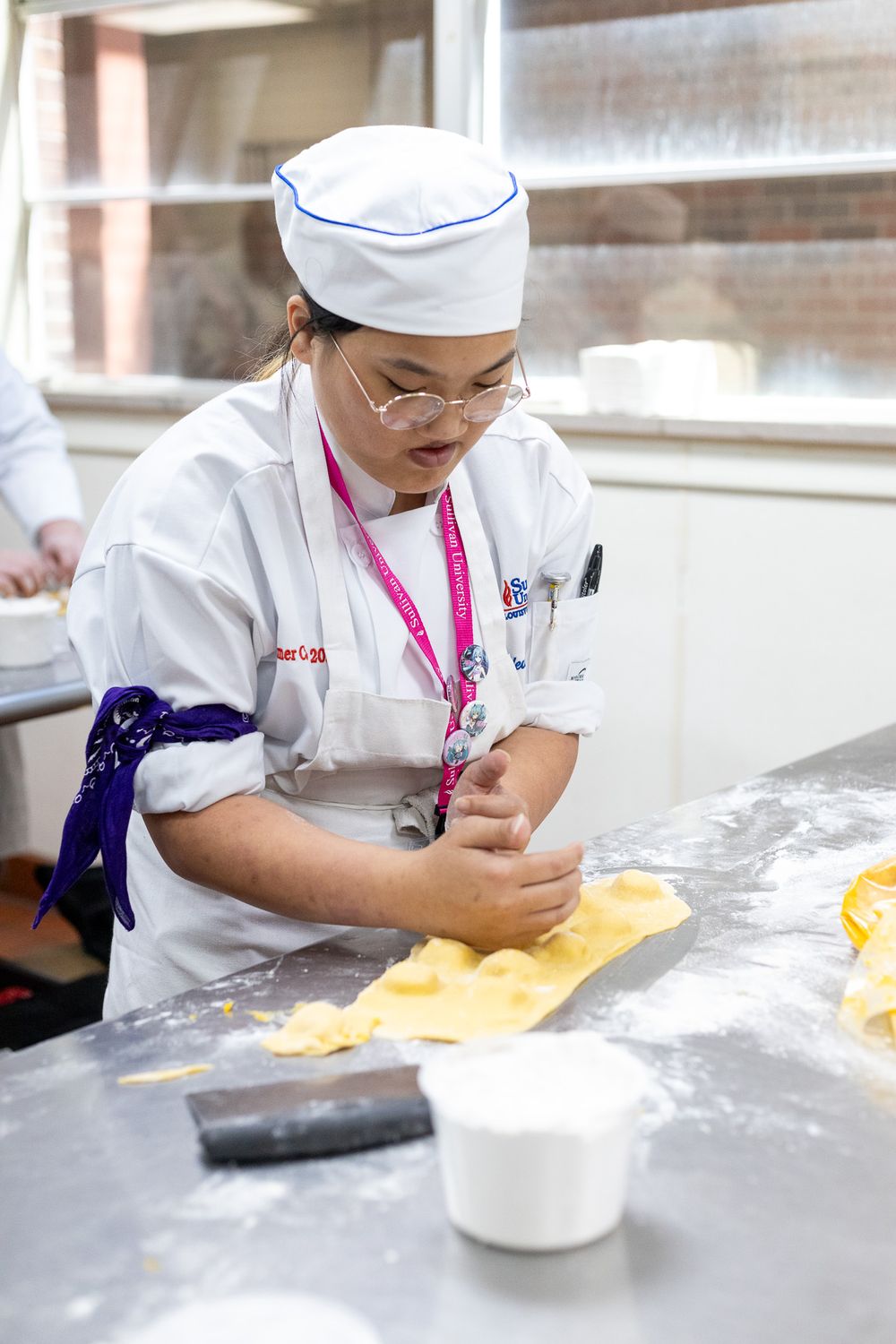 Culinary student rolling out pasta dough