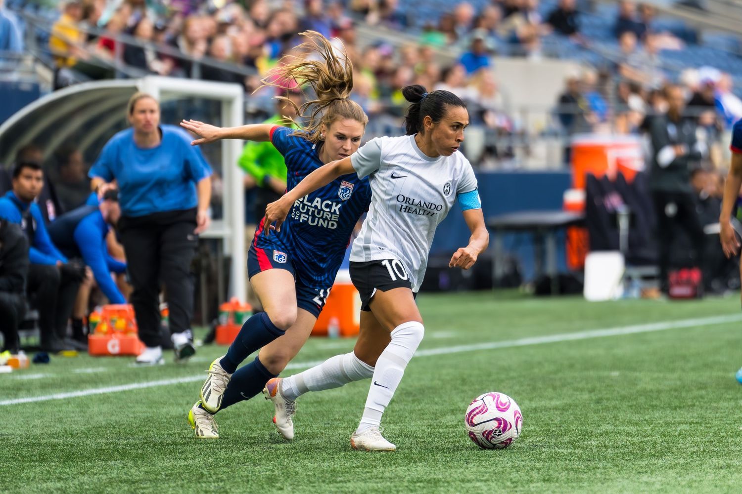 Legendary women's soccer player Marta Vieira da Silva dribbles past a defender from OL Reign during an NWSL match.