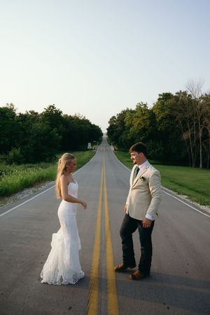 Married couple look at each other on beautiful country road.