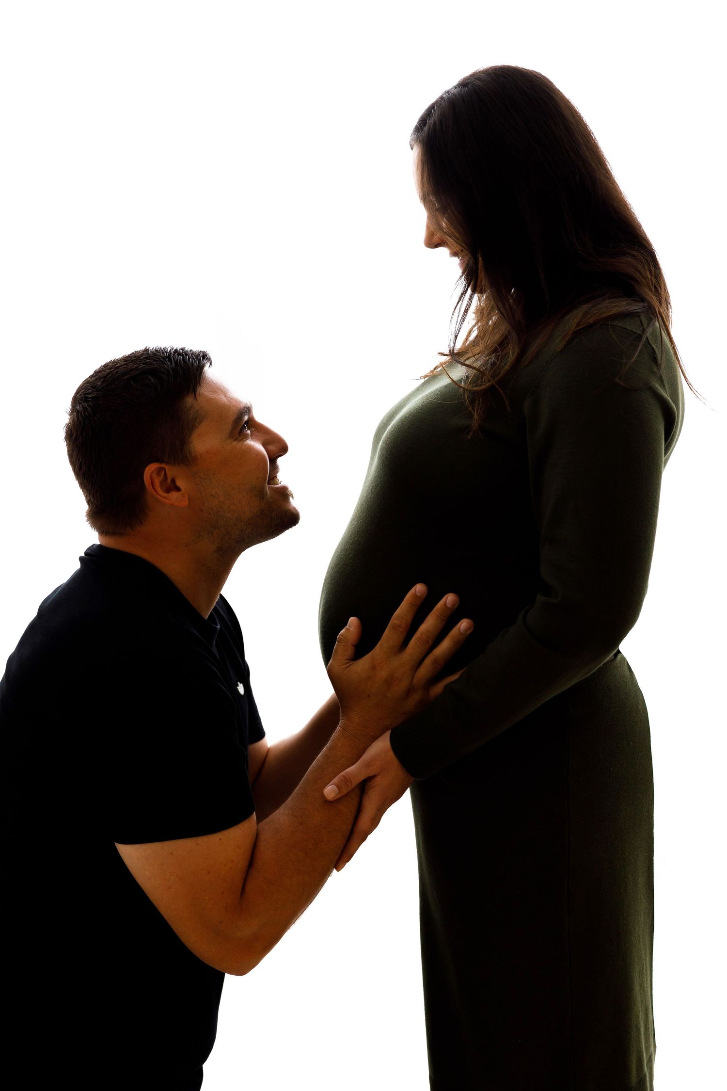 Silhouette maternity photo showing tender moment between couple.