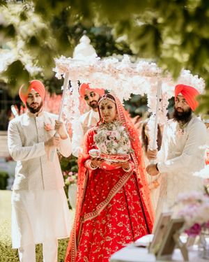 Traditional Indian wedding ceremony with ornate white canopy and floral decorations.