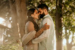 Romantic couple embraces in a dreamy sunlit forest setting with golden bokeh lighting effects.