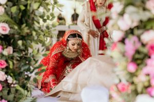 Traditional wedding ceremony amidst pink roses and floral decorations outdoors.