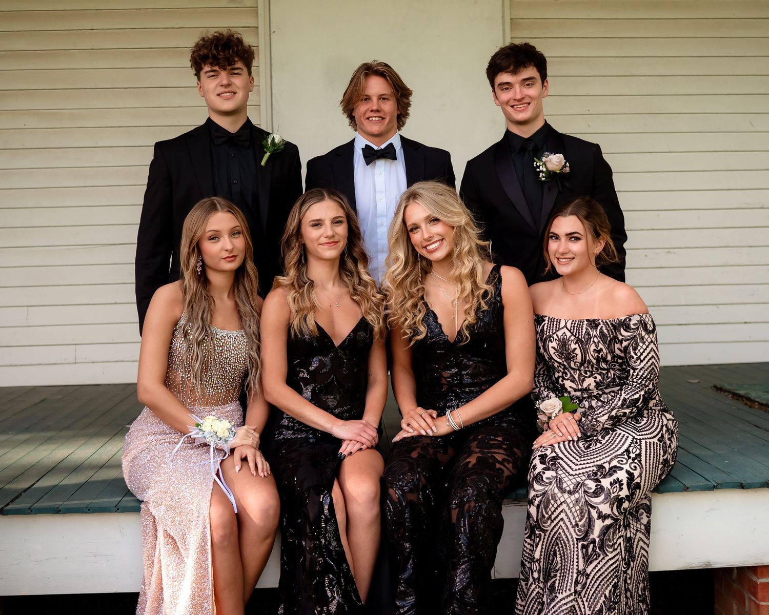 Formal group photo of students in suits and dresses at special event.