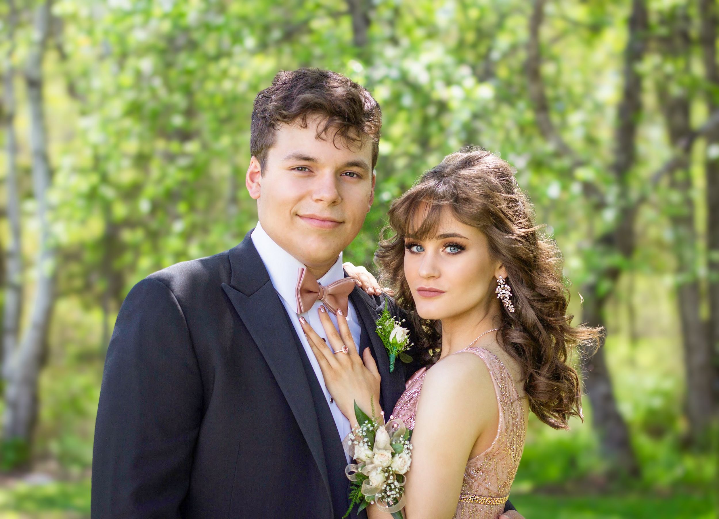 Prom photo of a couple taken outdoors in front of greenery with natural light by portrait photographer Daneesha Williams