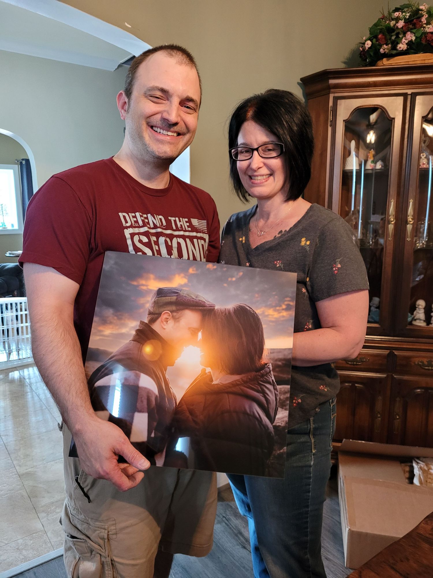 Photography enthusiasts display sunset landscape prints in home setting.